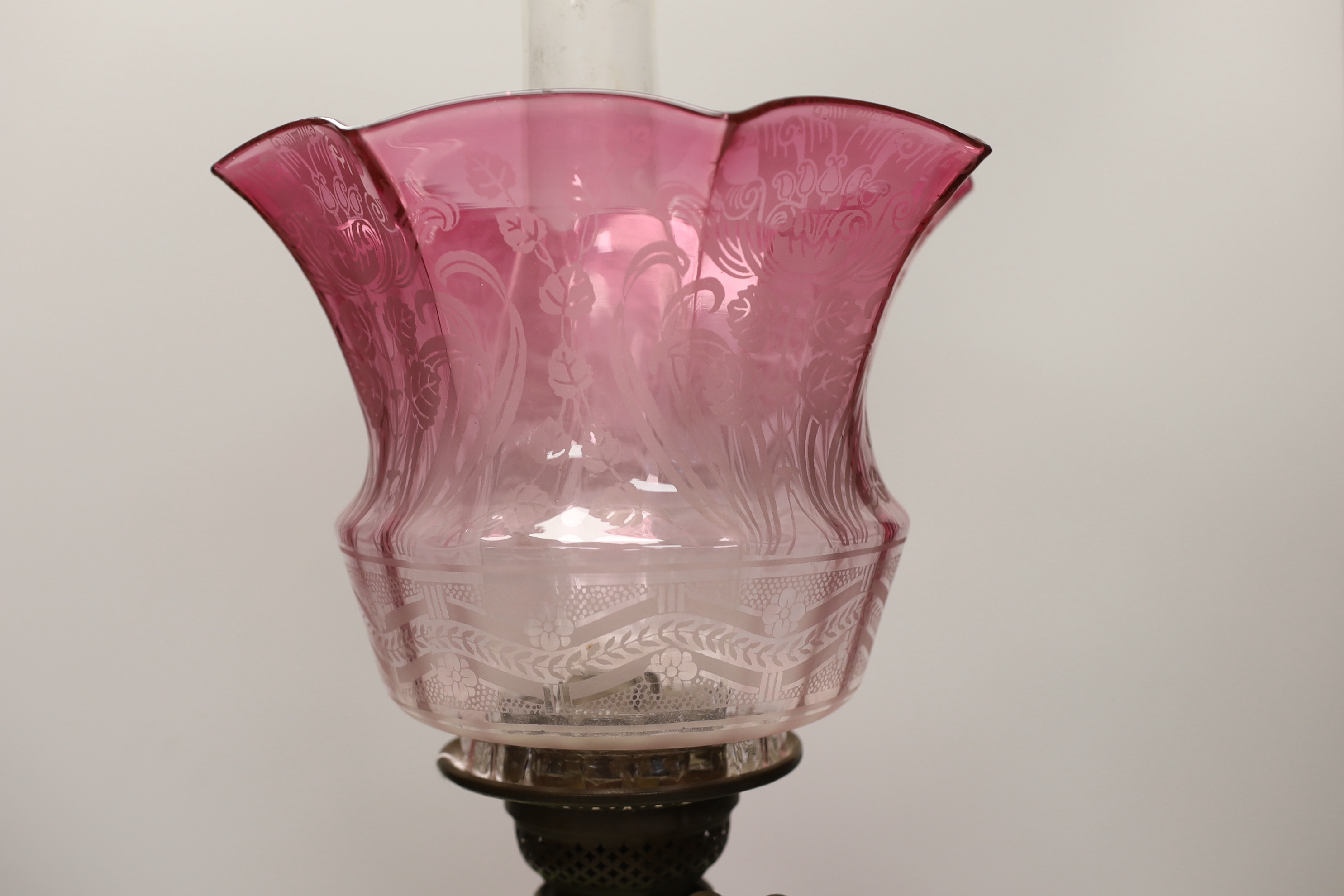 A Victorian brass and glass oil lamp, with cranberry shade, 58cm high including funnel